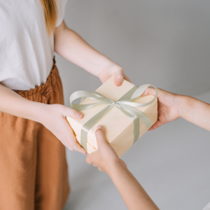 2 personnes s'échangent un cadeau de la main à la main