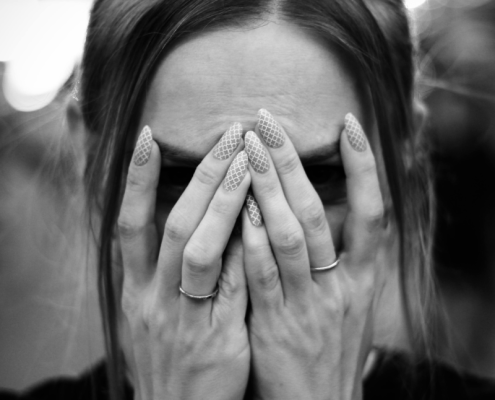 femme qui se cache les yeux avec ses mains