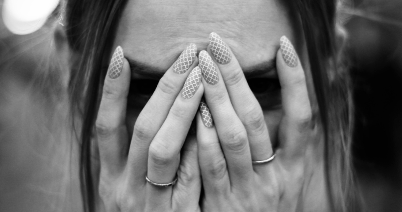 femme qui se cache les yeux avec ses mains