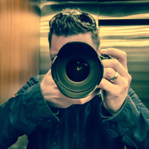 homme qui nous vise avec son appareil photo